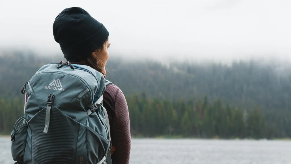 girl camping backpack at fall foggy morning