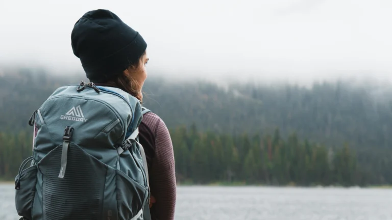 girl camping backpack at fall foggy morning